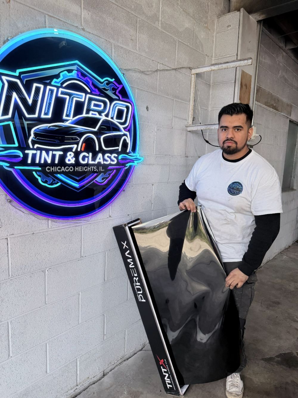 Nitro Tint & Glass technician holding a sheet of UVIRON PUREMAX window film